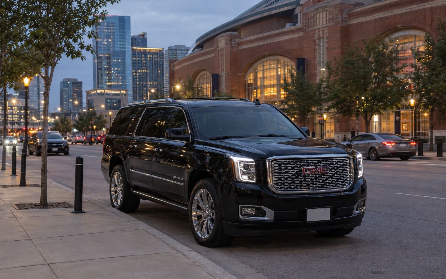Black GMC Yukon parked at the curb beside American Airlines Center in Dallas