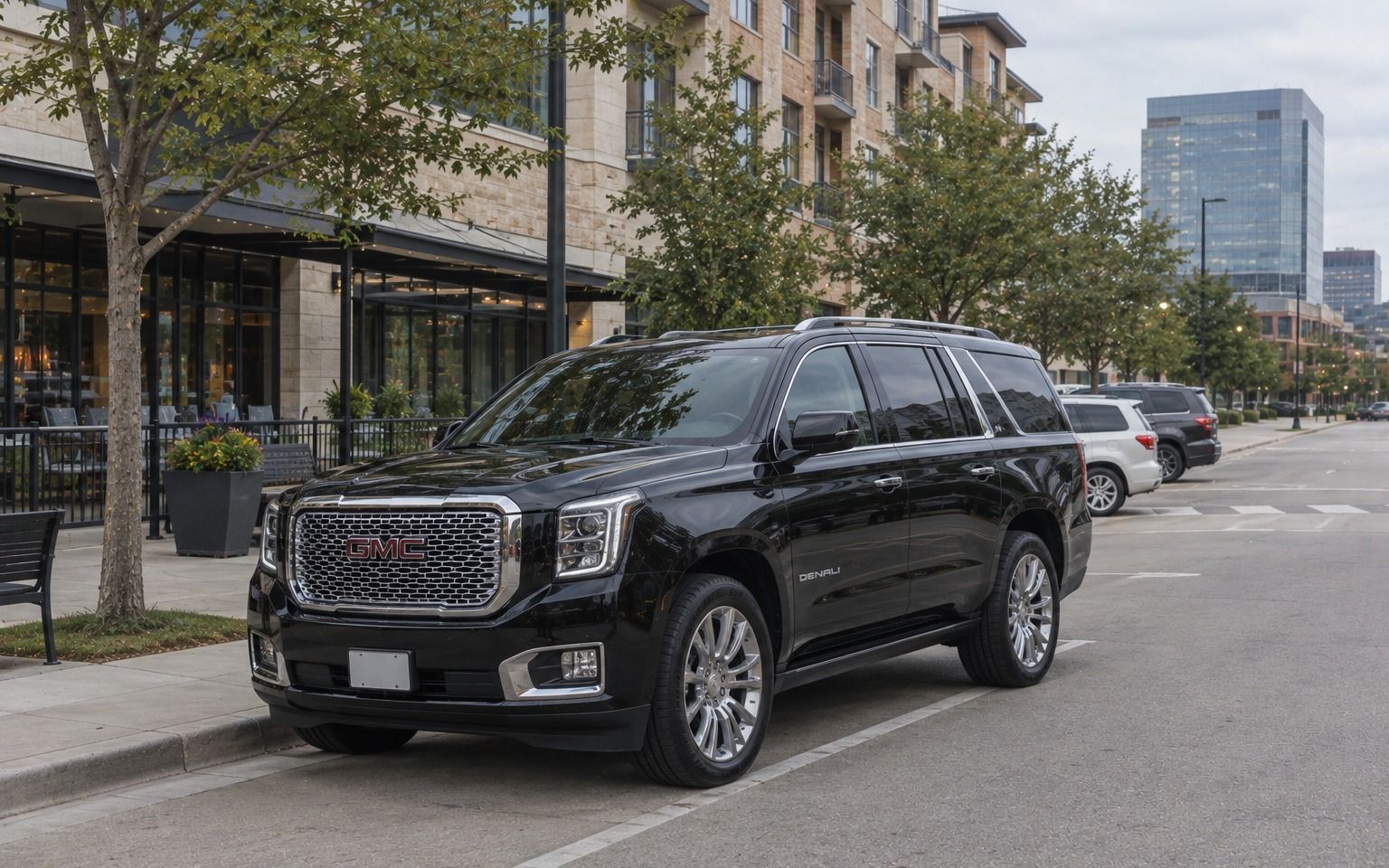 Black GMC Yukon parked on a street of shops and offices in Plano